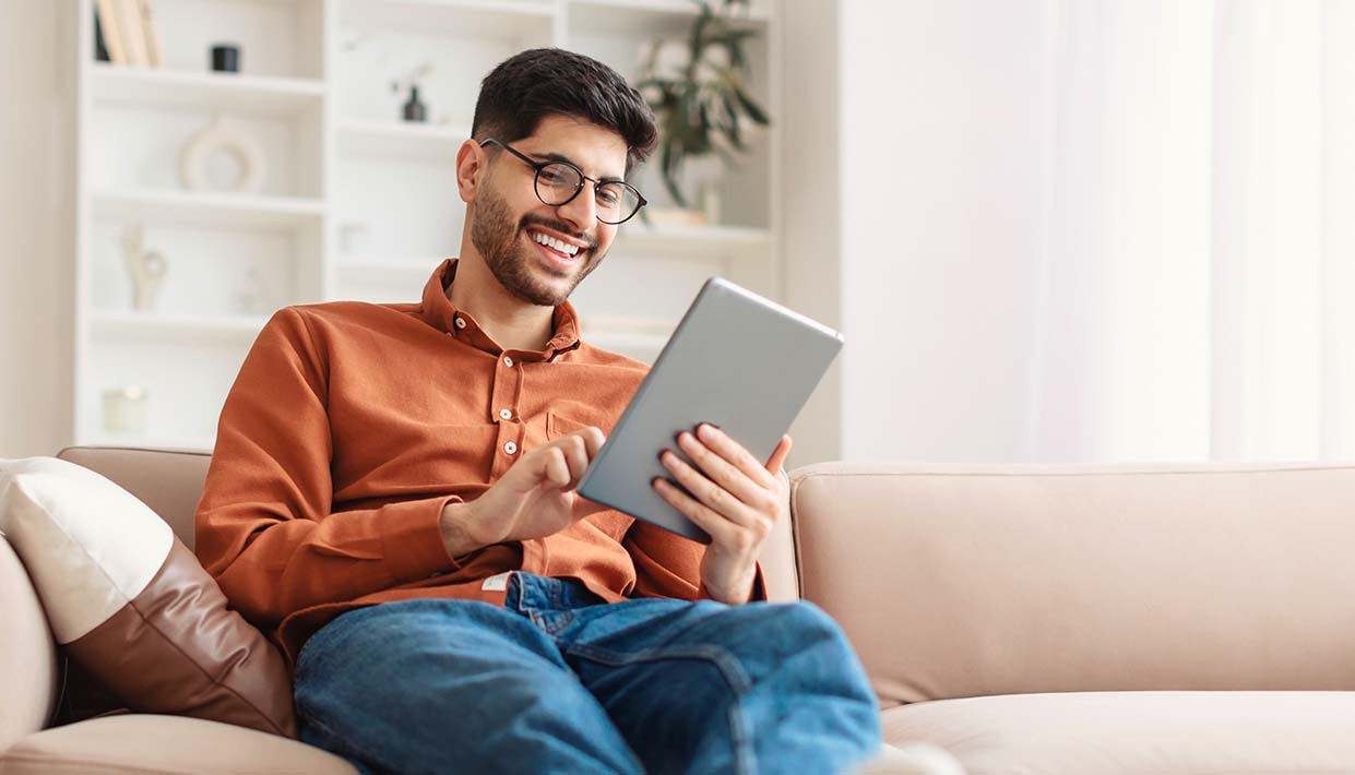 Junger Brillenträger am Tablet