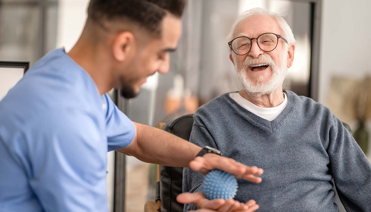 Patient bekommt mit einem Massageball die Hand massiert 