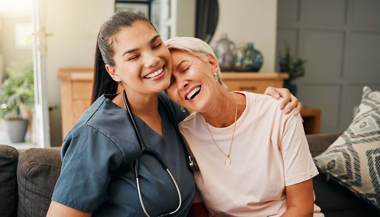 Pflegerin umarmt Patientin