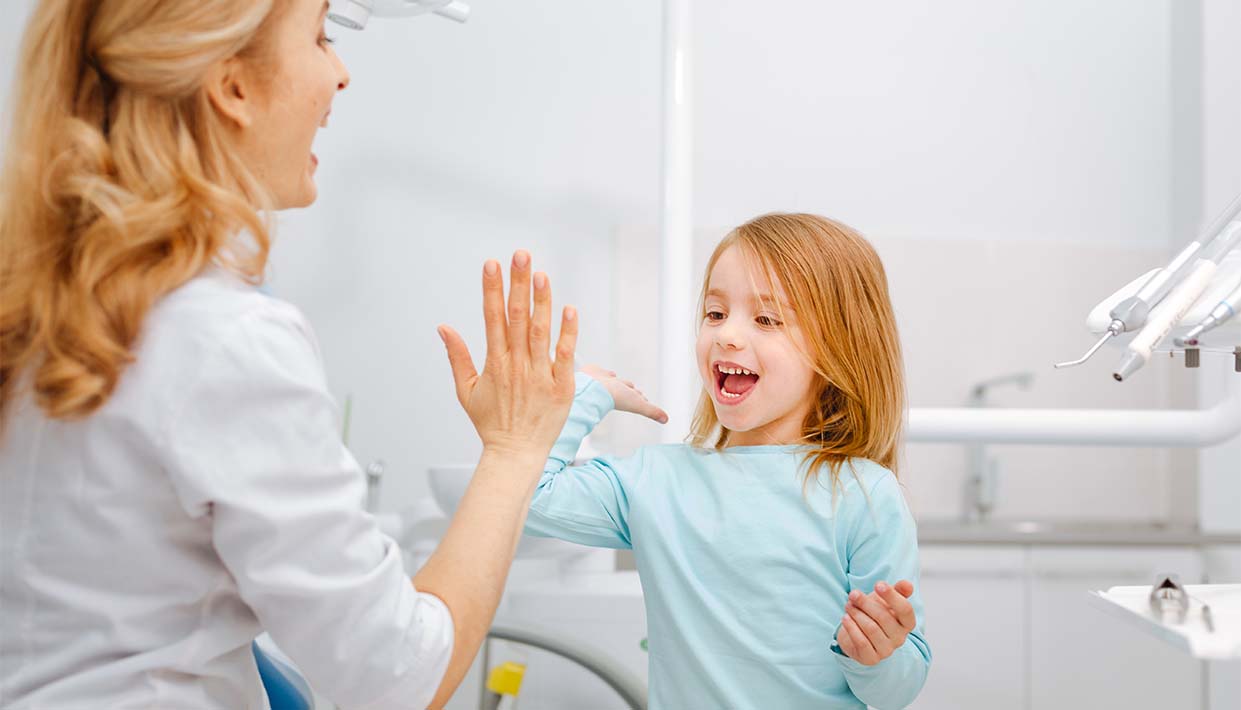 Zahnärztin gibt Kind ein high five 